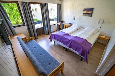 a hospital room with a bed and a window at Innvik Fjordhotell in Innvik