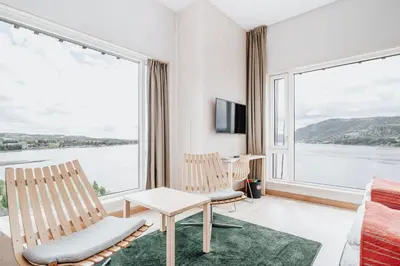 a living room with two chairs and a large window at Wood Hotel by Frich's in Brumunddalen