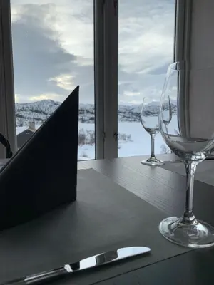 a table with two wine glasses and a laptop on it at Vågslidtun Hotel in Vågsli