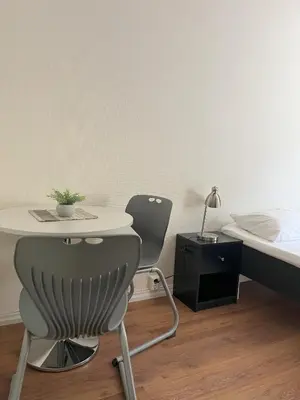 a bedroom with a bed and a table and a chair at Birkelunden Bed & Breakfast in Rjukan