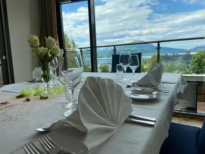 a table with a white table cloth and glasses and flowers at Havila Hotel Ivar Aasen in Ørsta