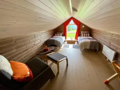 a room with three beds and a window at Heinåli Hytta in Isfjorden