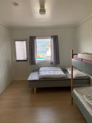 a bedroom with two bunk beds and a window at Solvang Ferietun in Vangsnes