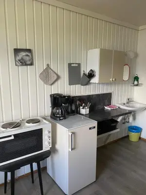 a kitchen with a white refrigerator and a sink at Solvang Ferietun in Vangsnes
