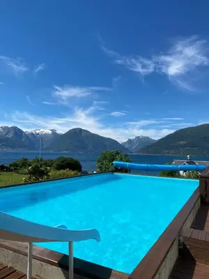a swimming pool with a view of the mountains at Solvang Ferietun in Vangsnes