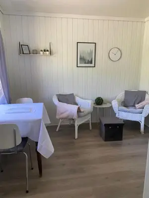 a room with chairs and a table and a table and chairs at Solvang Ferietun in Vangsnes