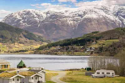 a view of a lake and mountains with a house at Hardanger Guesthouse in Ulvik