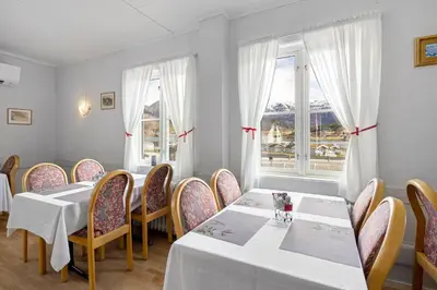 a restaurant with two tables and chairs and a window at Hardanger Guesthouse in Ulvik