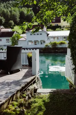 a porch with a white fence and a body of water at Stryn - house by the river in Stryn
