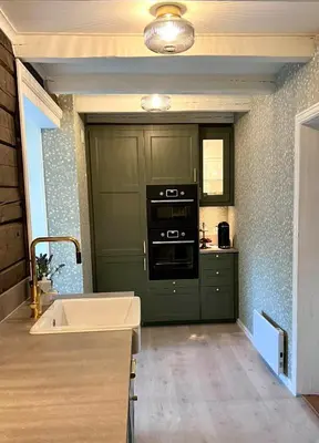 a kitchen with green cabinets and a stove top oven at Stryn - house by the river in Stryn