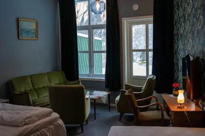 a hotel room with a bed and a table and chairs at Akrafjorden Nature B&B AS in Fjæra
