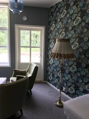 a room with a bed and a lamp and a chair at Akrafjorden Nature B&B AS in Fjæra