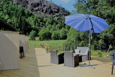 a blue umbrella sitting on top of a wooden deck at Akrafjorden Nature B&B AS in Fjæra
