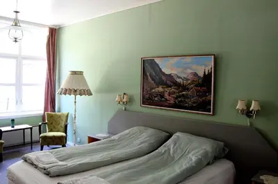 a bedroom with a bed with a painting on the wall at Akrafjorden Nature B&B AS in Fjæra