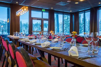 a long table in a restaurant with chairs and glasses at Skistar Lodge Trysil in Trysil