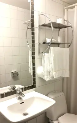 a bathroom with a sink and a toilet and towels at Rondane Høyfjellshotell in Mysusæter