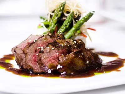 a plate with a piece of meat and asparagus at Rauland Høgfjellshotell in Rauland