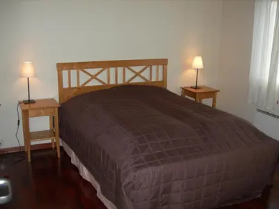 a bedroom with a bed and two night stands with lamps at Rauland Høgfjellshotell in Rauland