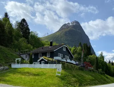 a house on a hill with a mountain in the background at Sunde panorama in Olden
