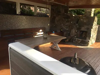 a wooden table on a patio with a fireplace at Sunde panorama in Olden