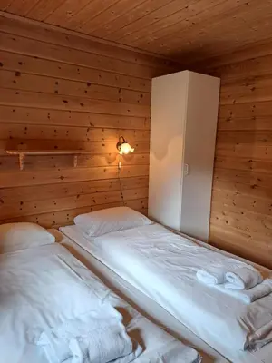 a bedroom with two beds in a wooden room at Stardalen Hyttegrend in Klakegg