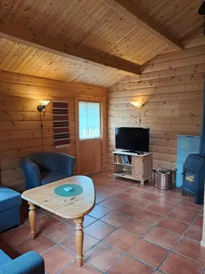 a living room with a table and a tv in a cabin at Stardalen Hyttegrend in Klakegg