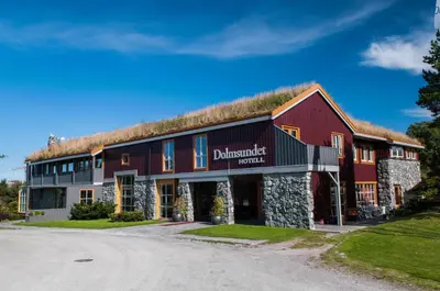 a large red building with a grass roof at Dolmsundet Hotell Hitra in Melandsjøen