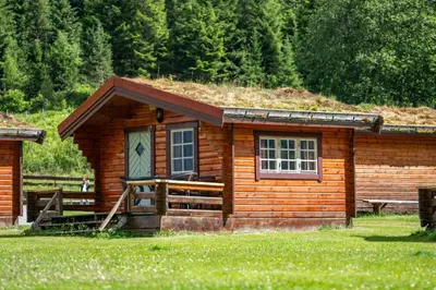 a small log cabin with a grass roof at Trollstigen Camping and Gjestegård in Åndalsnes