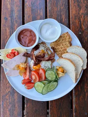 a plate of breakfast food with bread and dips at Trollstigen Camping and Gjestegård in Åndalsnes