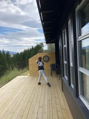 a young boy standing on a wooden deck at Voss Hytte/Cabin in Skulestadmo