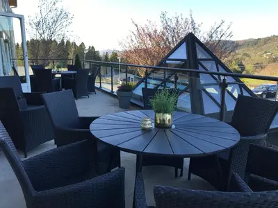 a patio with a blue table and chairs on a balcony at Alver Hotel in Alversund