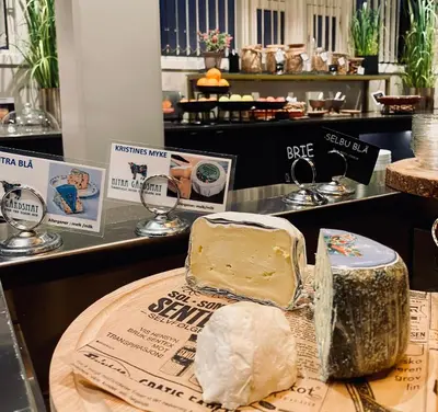 a display of cheese on a table in a store at Hotel Frøya in Sistranda