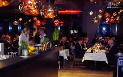 a group of people sitting at tables in a restaurant at Hotel Frøya in Sistranda