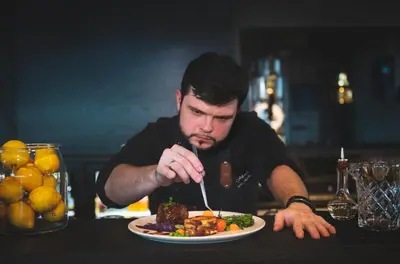 a man sitting at a table eating a plate of food at Hotel Frøya in Sistranda