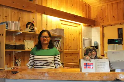 a woman standing at a counter in a kitchen at Jotunheimen Feriesenter in Heidal