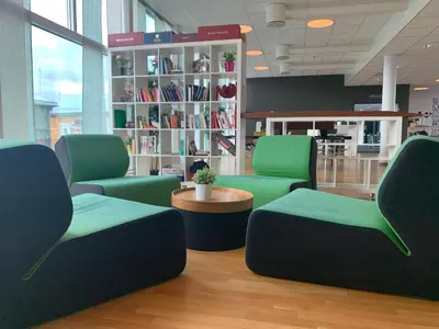 a waiting room with green chairs and a table at P-Hotels Brattøra in Trondheim