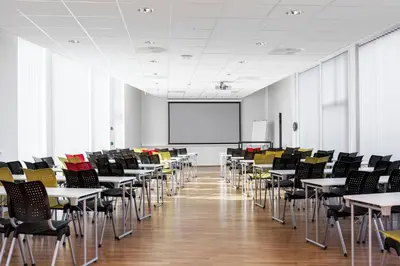 a classroom with tables and chairs and a whiteboard at P-Hotels Brattøra in Trondheim