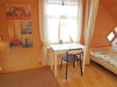 a bedroom with a table and a bed and a window at Fully equipped flat, 2 bedrooms, FREE car parking. in Trondheim