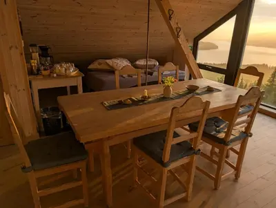 a dining room with a wooden table and chairs at Granum Gård in Fluberg