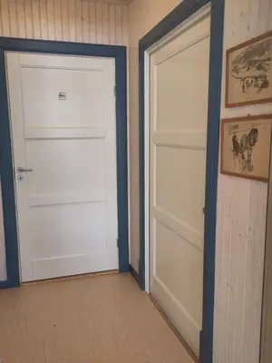 two white garage doors in a room at Granum Gård in Fluberg
