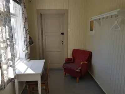 a room with a table and a chair and a door at Granum Gård in Fluberg