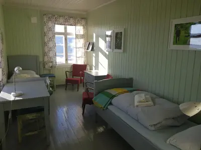 a bedroom with a bed and a desk and a table at Granum Gård in Fluberg