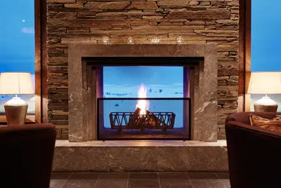 a fireplace in a living room with a fire in it at Pellestova Hotell Hafjell in Hafjell