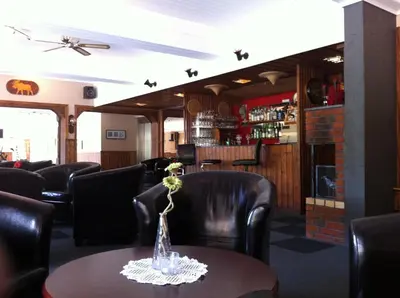 a dining room with a table and leather chairs at Vossestrand Hotel and Apartments in Myrkdalen