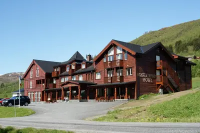 a large wooden building on the side of a road at Vossestrand Hotel and Apartments in Myrkdalen