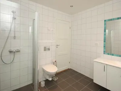 a white bathroom with a toilet and a shower at 6 person holiday home in Åram-By Traum in Sandvik