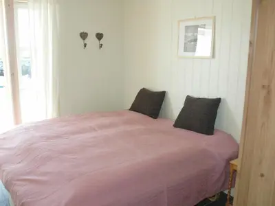 a bedroom with a bed with pink sheets and a window at 6 person holiday home in Åram-By Traum in Sandvik