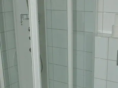 a shower in a bathroom with white tiles at 6 person holiday home in Åram-By Traum in Sandvik