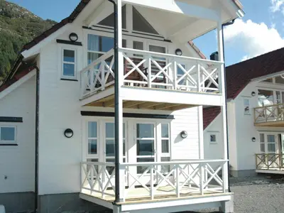 a large white house with a large deck at 6 person holiday home in Åram-By Traum in Sandvik