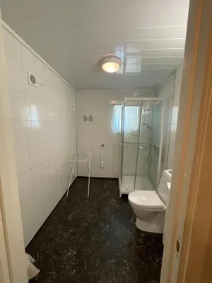 a bathroom with a toilet and a glass shower at Kvam - Stegastein in Aurland